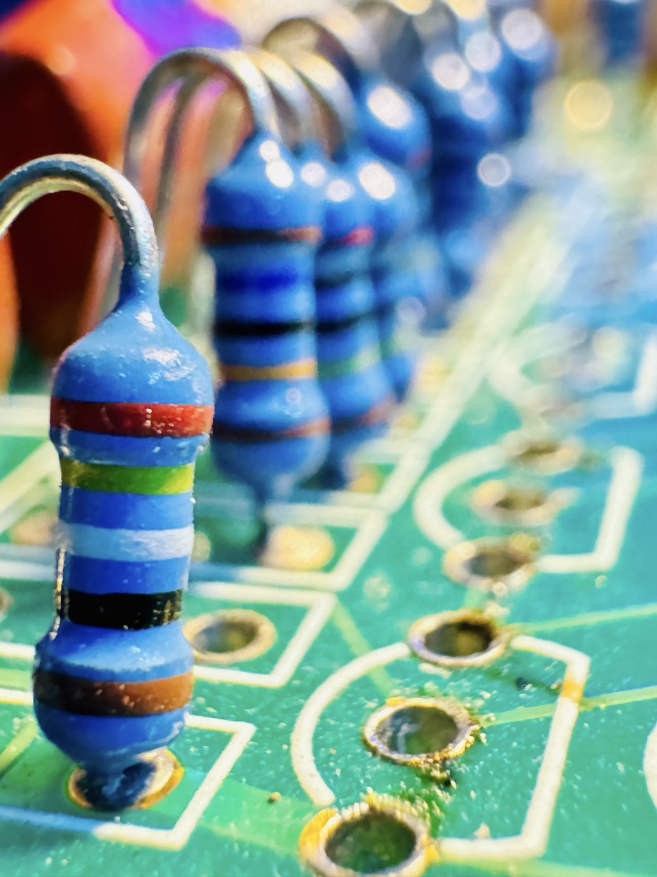 Resistor: A small cylindrical electronic component with color-coded bands, designed to limit electrical current by providing a specific resistance in a circuit.