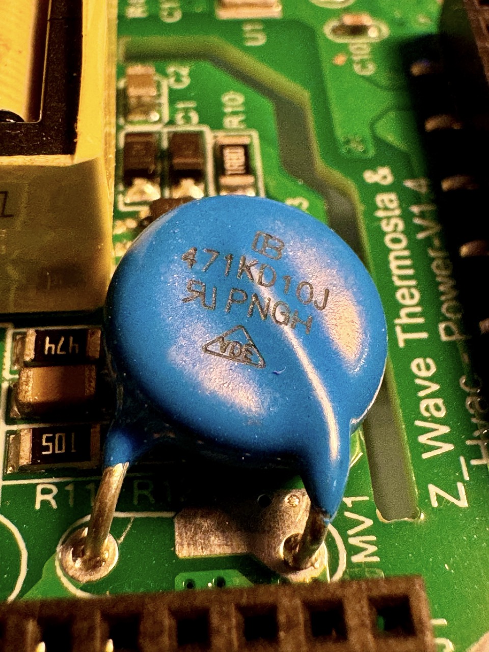 Varistor: A disk-shaped electronic component with two wire leads, used to protect circuits from voltage spikes by changing resistance based on applied voltage.